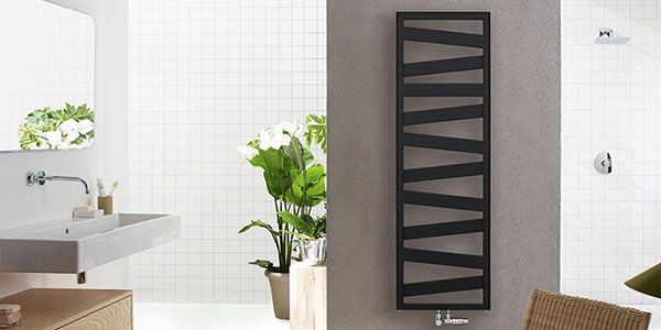 Ein schwarzer Designerheizkörper mit einer Art Zickzack Muster an der Wand